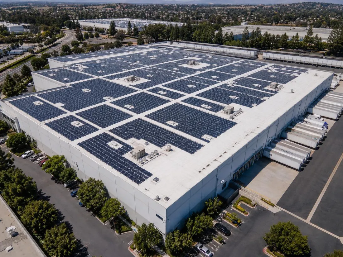 Aerial view of a Southern California warehouse with a full rooftop solar array on white TPO membrane